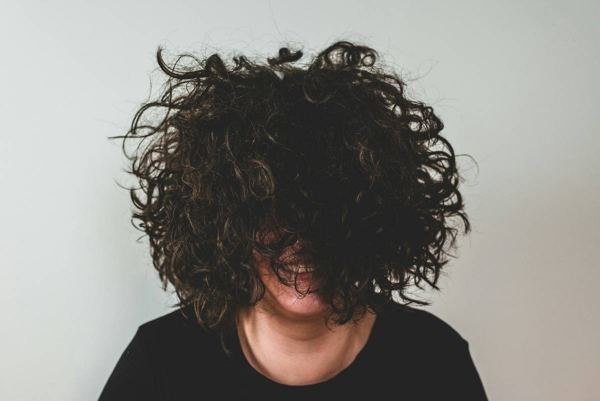 Woman with healthy curly hair practicing hair care for curly hair using protective styling methods